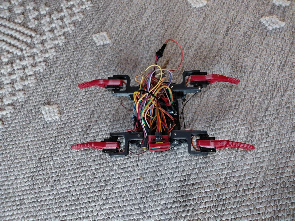 The early red printed robot on the carpet, with its mechanisms and wiring visible.