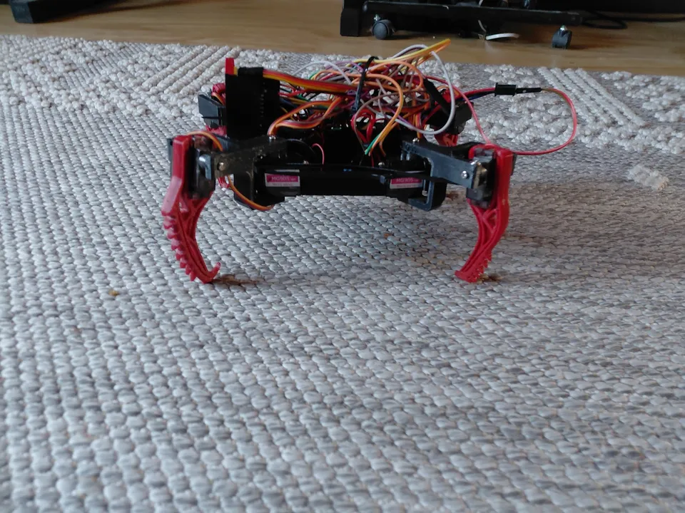 The early red printed robot on the carpet, with its mechanisms and wiring visible.