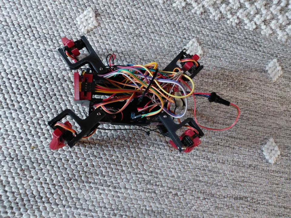 The early red printed robot on the carpet, with its mechanisms and wiring visible.
