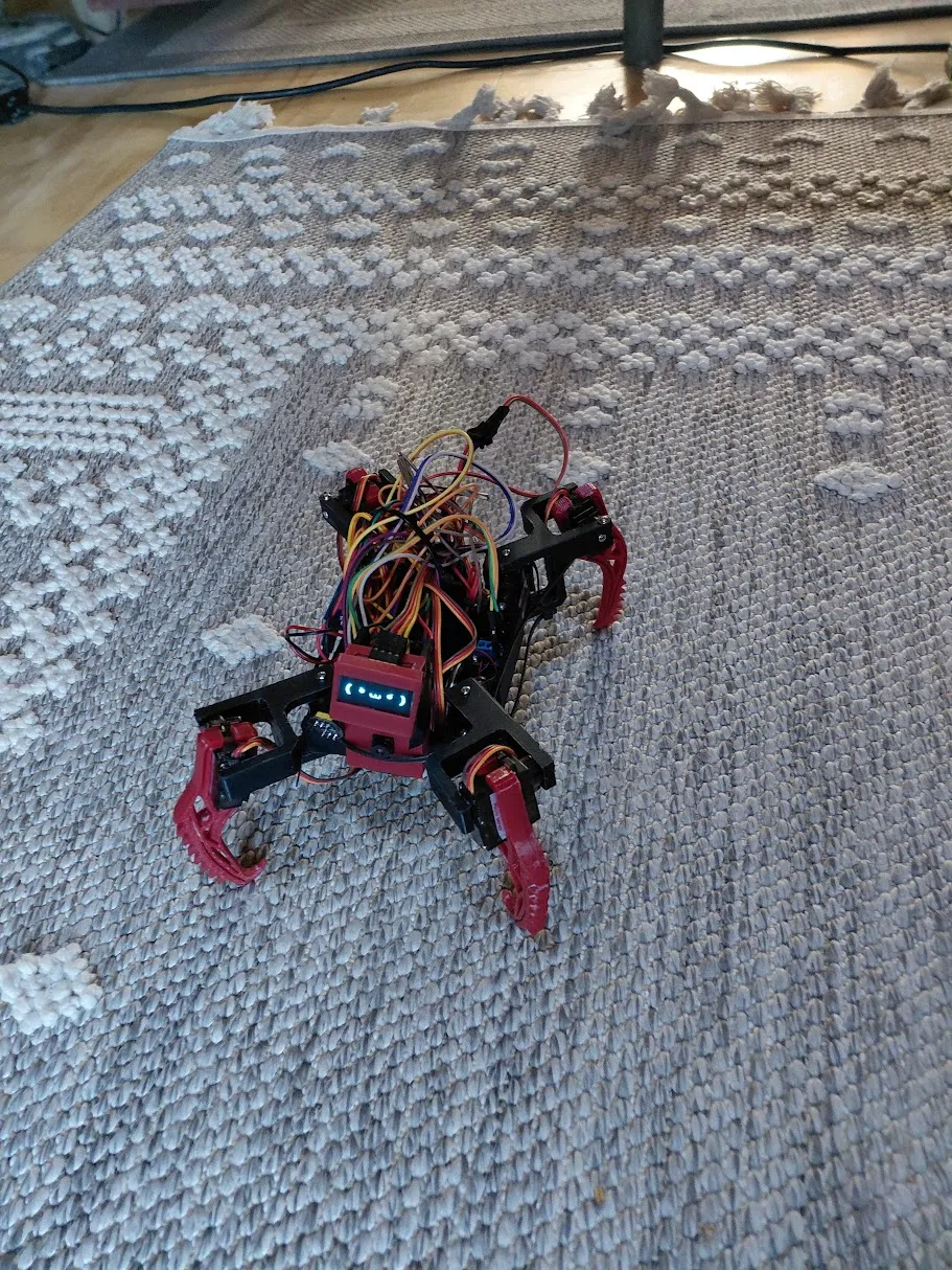 The early red printed robot on the carpet, with its mechanisms and wiring visible.