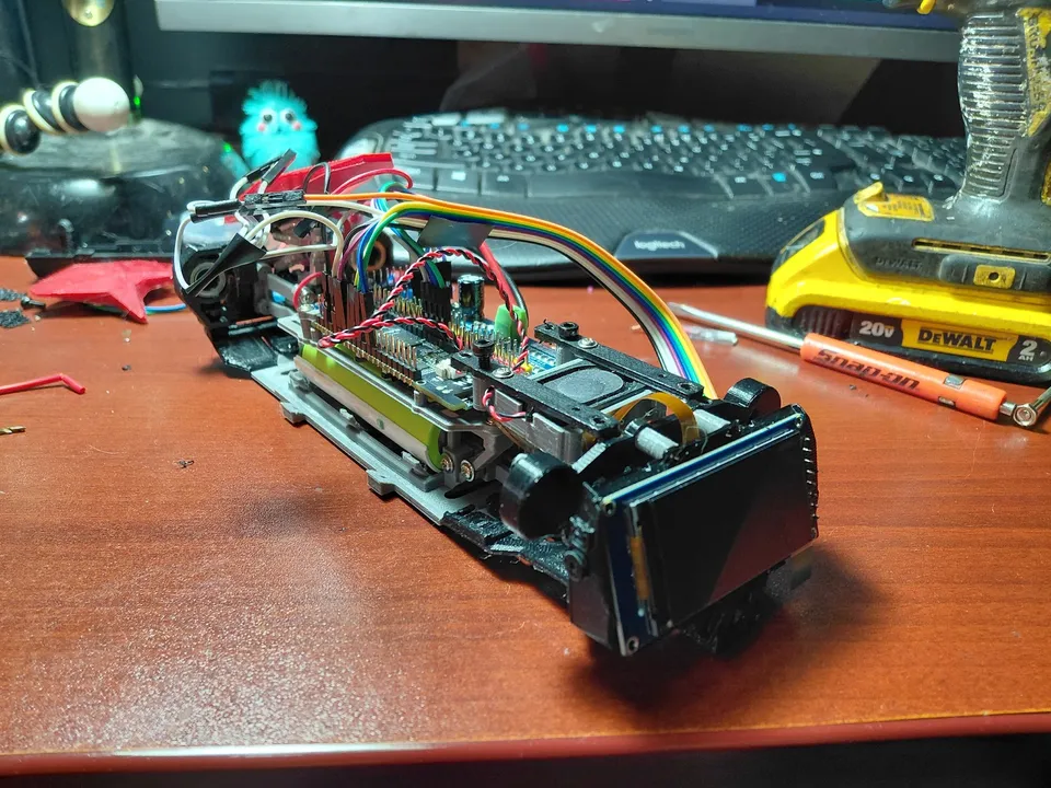 The open chassis on the workbench, with its display, electronics and wiring exposed.